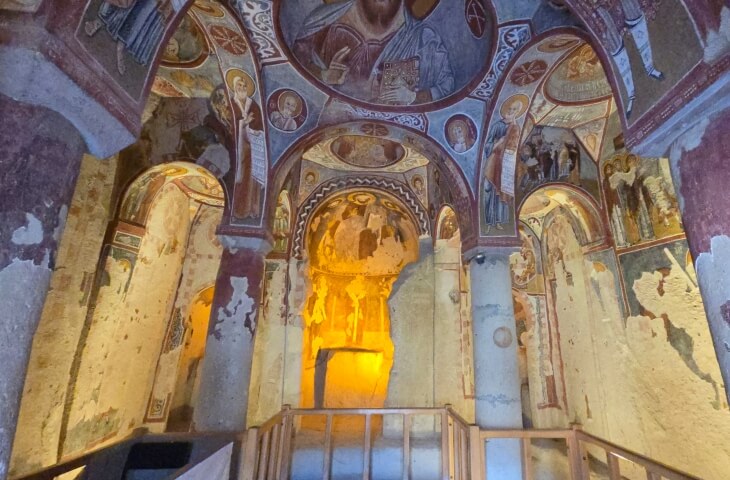 Elmalı Kilise’nin iç mekânı, kubbeyi çevreleyen freskler ve duvarlardaki aziz figürleriyle birlikte görülüyor.